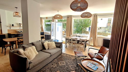 Modern cottage living room at Maison de Sophie in Rencurel with gray sofa, dining area, and large windows overlooking