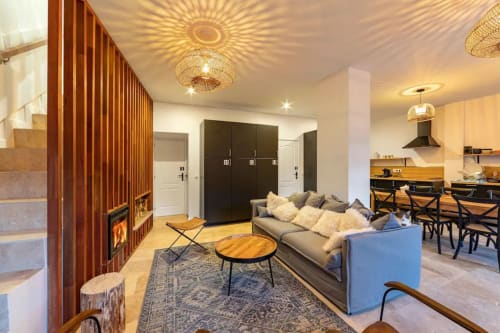 Modern open-plan cottage at Maison de Sophie in Rencurel with fireplace, gray sofa, dining area and kitchen