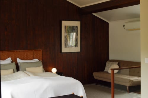 Bedroom at Villa Várzea with dark wood paneling, white bedding, woven headboard, and modern furnishings in Várzea