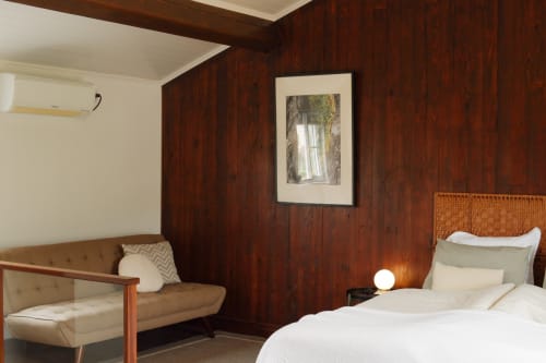Warm wooden bedroom at Villa Várzea with bed, sitting area, and framed artwork in Várzea, Portugal