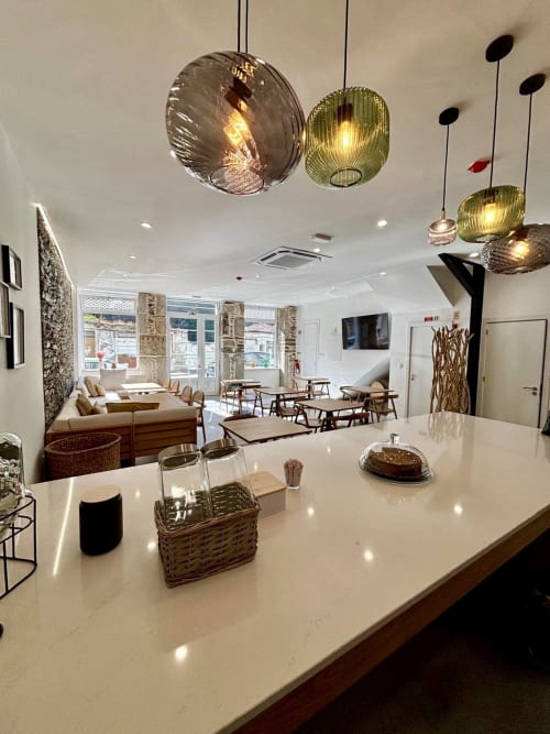 Lounge Casa Tawny Pinhão com balcão branco, luminárias pendentes e áreas de estar aconchegantes