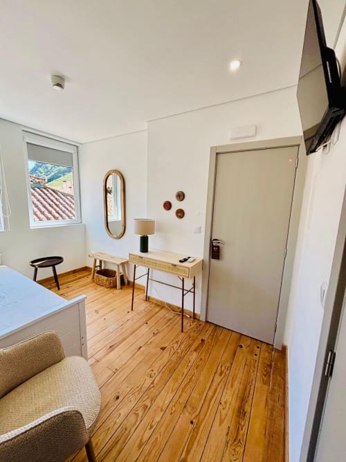 Quarto moderno da Casa Tawny B&B em Pinhão com piso de madeira, escrivaninha, espelho e vista das janelas