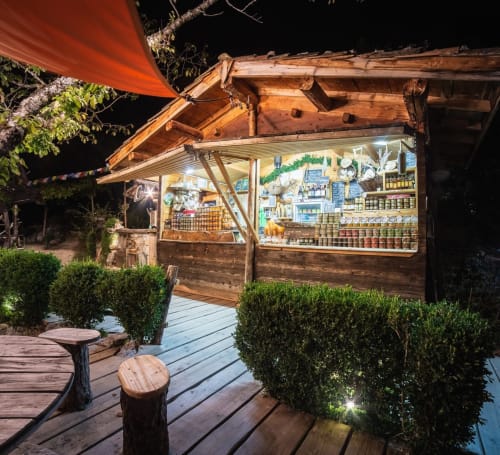 Maison de Sophie's charming nighttime shop display in Rencurel, featuring rustic wooden structure with illuminated storefront