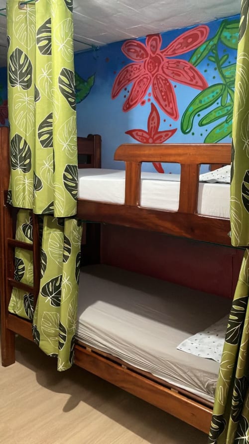 Aconchegante beliche com cortinas de folhas de limão no quarto Forest do Hostel New Ipanema, Rio de Janeiro, com arte tropical nas paredes