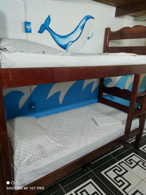 Beliche com colchões brancos e painel decorativo com design de ondas azuis no Hostel New Ipanema, Rio de Janeiro