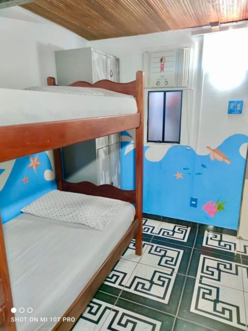 Quarto infantil colorido da Hostel New Ipanema no Rio de Janeiro com beliches de madeira e decoração temática do oceano.