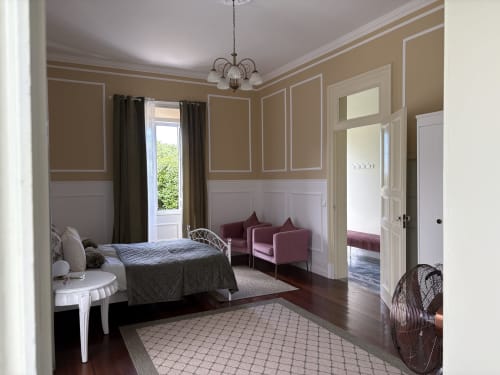 Garden Suite bedroom at Villa Várzea with elegant décor, seating area, and garden view through terrace doors