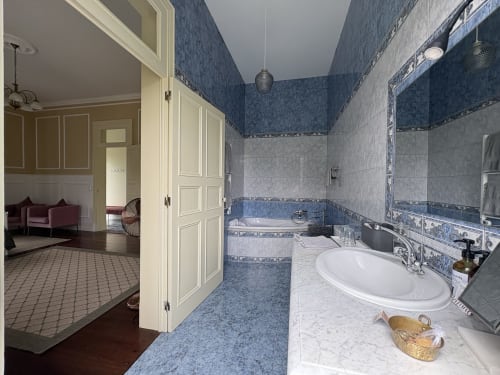 Luxurious bathroom at Villa Várzea Garden Suite with blue tiled walls, white sink, and bathtub in Várzea, Portugal