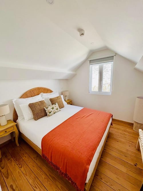 Touriga Franca Comfort Suite bedroom at Casa Tawny, Pinhão with wooden bed, orange throw, and dormer window