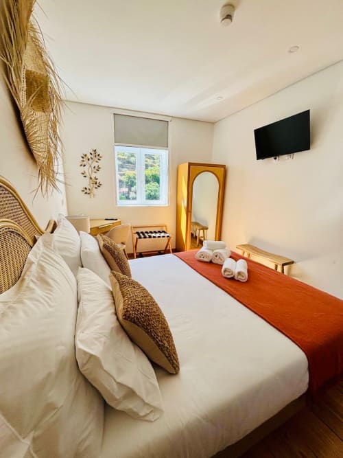 Touriga Nacional double room at Casa Tawny in Pinhão with white bedding, wicker chair, TV, and window overlooking gardens