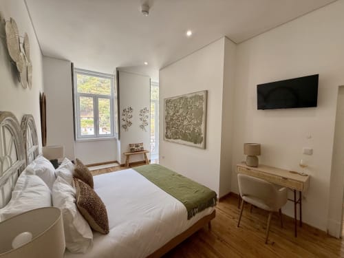 Spacious double bedroom at Casa Tawny with balcony, white bedding, wooden desk, flat-screen TV, and mountain views in Pinhão