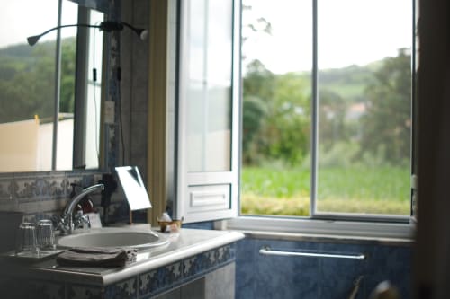Elegant bathroom at Villa Várzea with round sink, countryside view, and green hills in Várzea, Portugal