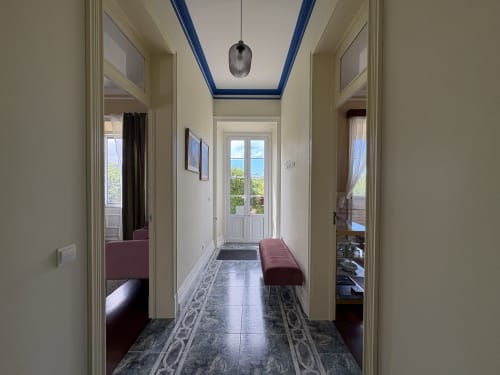 Elegant hallway at Villa Várzea with blue ceiling trim, patterned floor, and views to ocean and terrace