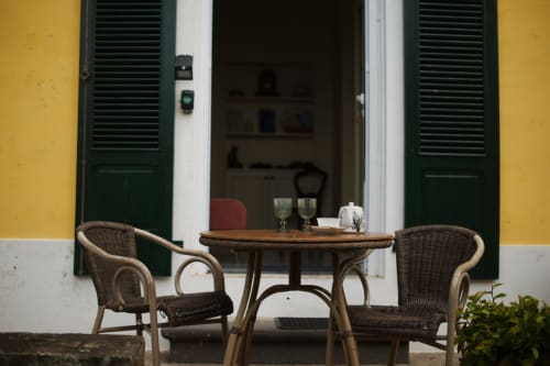 Cozy patio seating at Villa Várzea in Várzea with wicker chairs, wooden table, and colonial architecture