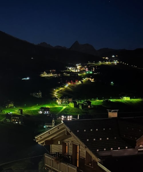 Hotel Al Dos a Livigno di notte, affascinante villaggio alpino illuminato tra le montagne sotto un cielo stellato