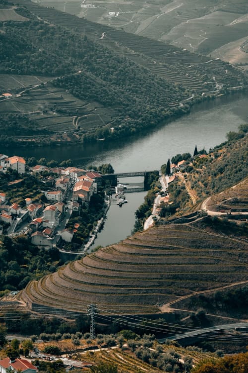 Aerial view of Pinhão's Douro Valley with terraced vineyards, riverside town, and bridge near Casa Tawny
