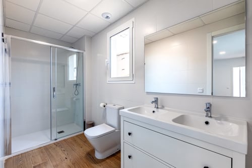 Cuarto de baño moderno en Residencia Demar, Godella con lavamanos doble, ducha de cristal y piso de madera