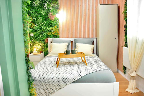 Modern bedroom at Wellkhome Appartements in Bordeaux with green plant walls, wooden breakfast table, and city view