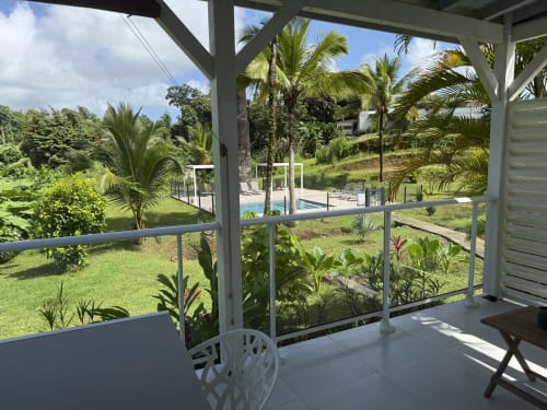 Véranda du Bungalow Héliconia donnant sur les jardins tropicaux et la piscine du Domaine de la Glacière, Petit-Bourg