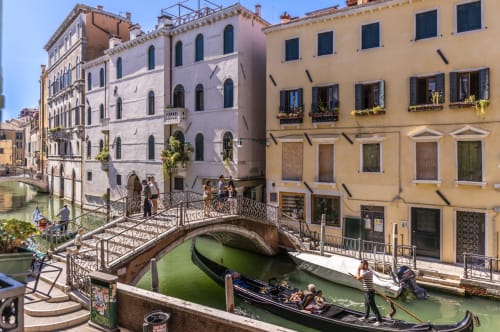 Palazzo San Firmino Venezia: vista del canale con gondola, ponte arcuato e edifici storici sul fronte acqueo sotto cielo azzurro limpido