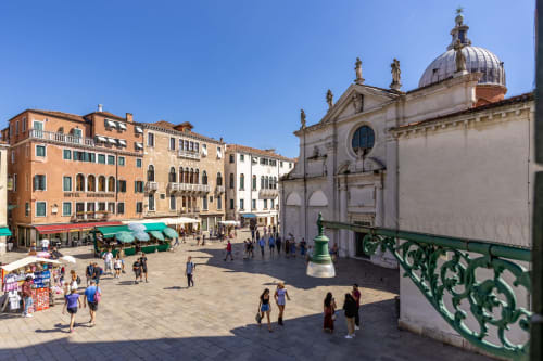 Piazza San Marco a Venezia con basilica storica, edifici rinascimentali e turisti nella soleggiata piazza italiana