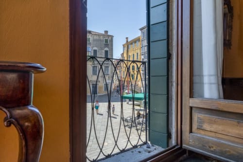 Balcon avec vue sur canal à Venise, élégante balustrade dominant la place historique de l'hôtel Palazzo San Firmino