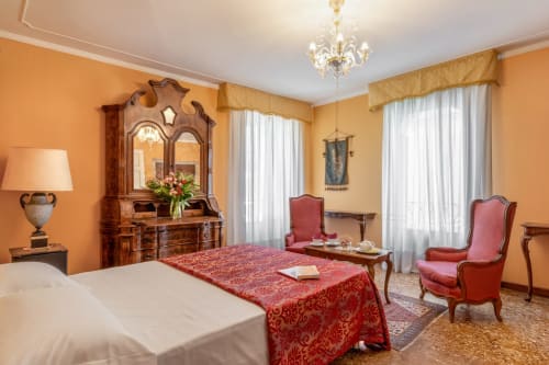 Élégante suite royale avec balcon au Palazzo San Firmino à Venise, mobilier en bois ouvragé, dessus-de-lit en damas rouge