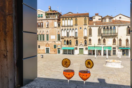 Cocktails d'apéritif sur un balcon de Venise dominant une place historique au Palazzo San Firmino
