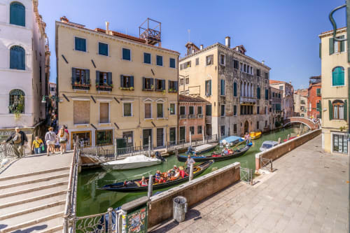 Vue du Grand Canal à Venise avec gondoles colorées, palais historiques et promenade waterfront au Palazzo San