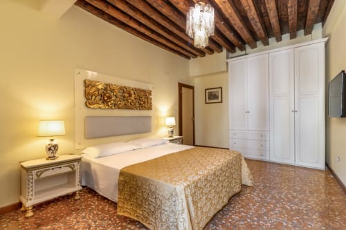 Suite Junior spacieuse du Palazzo San Firmino à Venise avec poutres apparentes, literie damassé or et armoire blanche
