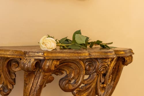 Rose blanche avec feuillage vert sur console en bois ouvragé dans une chambre de l'hôtel-boutique Palazzo San Firmino, Venise