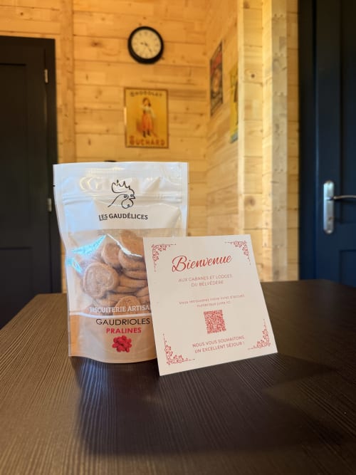 Dolcetti di benvenuto alle Cabanes et lodges du Belvédère: biscotti al pralinato e cartolina di benvenuto sul tavolo della camera