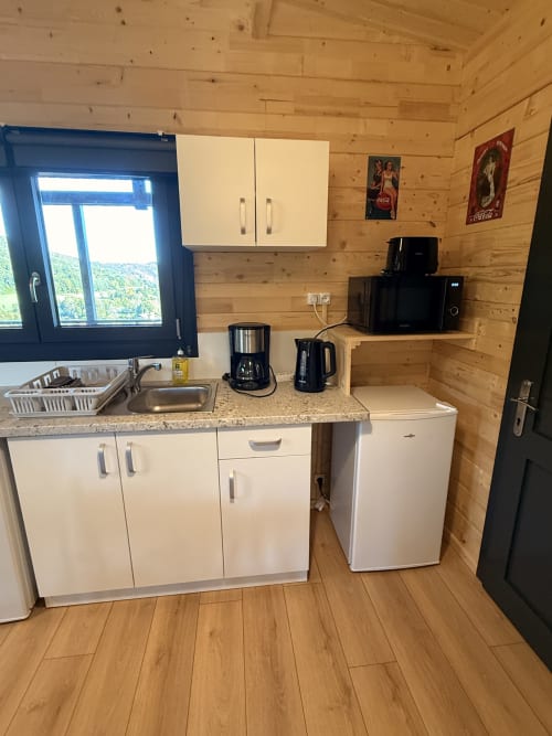 Cucina moderna nel Lodge LE CHAMOIS alle Cabanes du Belvédère con mobili bianchi, lavello in acciaio inox e elettrodomestici in legno