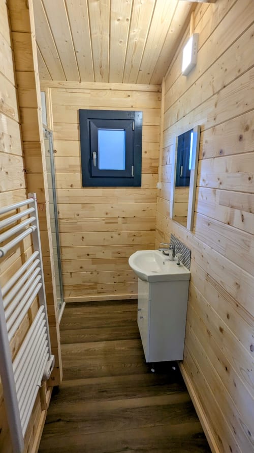 Interno moderno del bagno in legno al Lodge LE CHAMOIS delle Cabanes et lodges du Belvédère, con lavabo a piedistallo bianco e