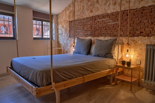 Cama suspendida con cuerdas en habitación moderna de ladrillo en hotel MoneoHeritage, Salamanca, España