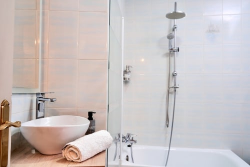 Baño moderno en Alojamiento Turístico MoneoHeritage de Salamanca con lavabo tipo vasija, ducha de lluvia y azulejos blancos