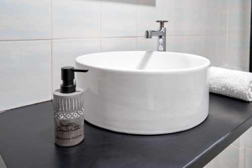 Lavabo circular blanco moderno con dispensador de jabón negro en el baño tipo loft MoneoHeritage, Salamanca