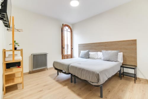Habitación moderna del hotel MoneoHeritage en Salamanca con cama de madera, calefacción radiante y ventana ojival elevada