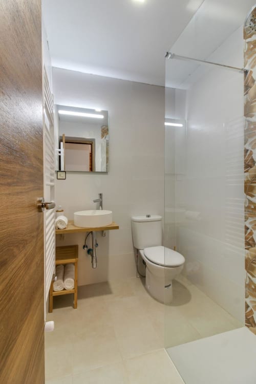 Baño moderno en Estudio San Pablo del hotel MoneoHeritage, Salamanca, con accesorios blancos y detalles en madera
