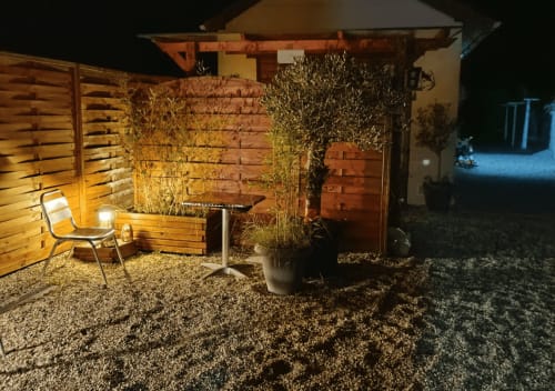 Vue nocturne de la terrasse privée du studio Le Loup, gîte Lamotte-Beuvron en Sologne, éclairée avec ambiance chaleureuse et végétation décorative pour des soirées conviviales.