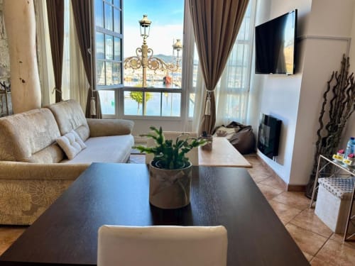 Elegante sala de estar con vistas al mar en apartamento frente al mar en Baiona, mobiliario moderno, TV y decoración costera