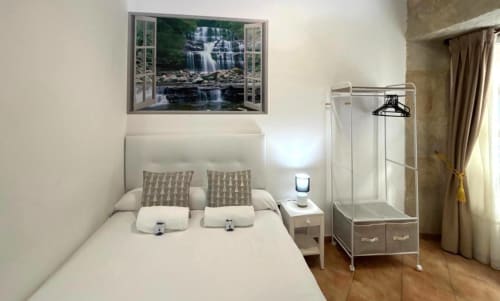 Dormitorio moderno en apartamento Solpor Boutique, Baiona: cama doble, vistas al mar, baño con ducha y suelos de madera
