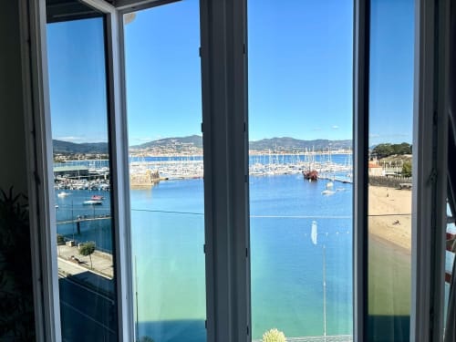 Vista desde el balcón del apartamento Holibai en Baiona, España, con vistas a la marina con veleros y playa