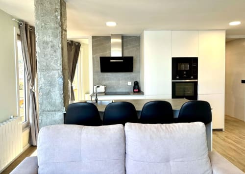 Cocina y comedor modernos en Baiona con vistas al mar, con muebles blancos, electrodomésticos negros y