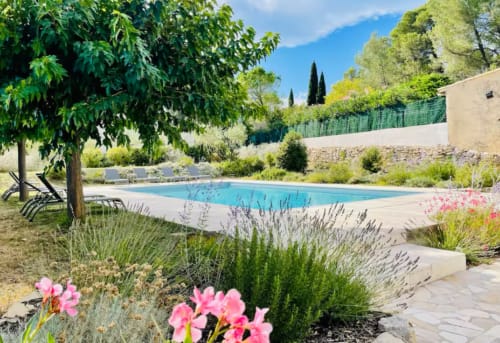 Glitzerndes blaues Swimmingpool umgeben von Lavendelgärten und Liegestühlen in der Villa La Conciergerie De Franck