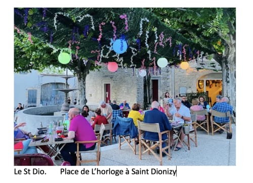 Outdoor dining event at Place de l'horloge, Saint Dionizy with colorful lanterns and guests enjoying dinner