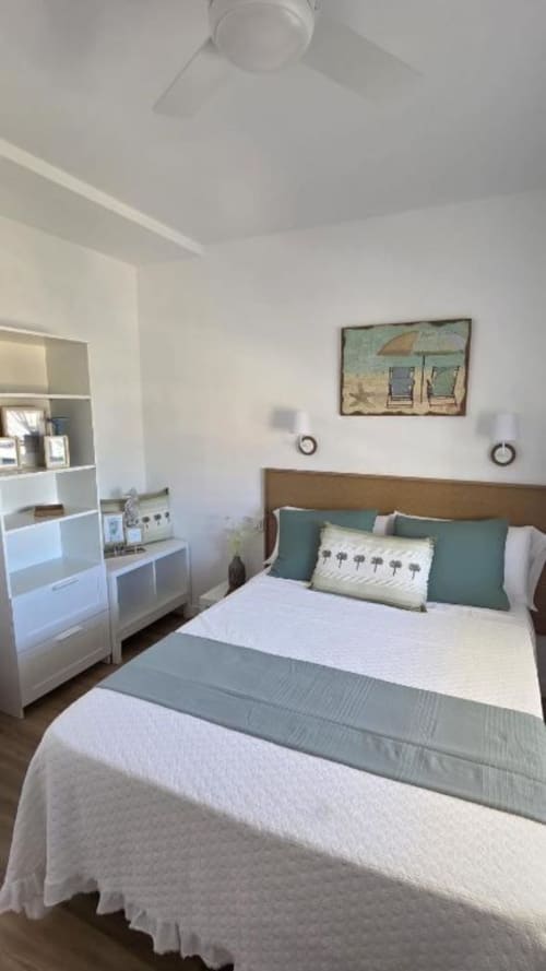 Dormitorio moderno con cama queen, arte con vistas al mar, muebles blancos y ventilador de techo en el apartamento Dream in the Sea, Benicàssim