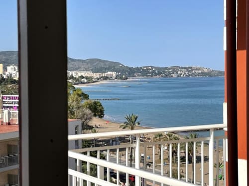 Vista al frente de playa desde balcón en Benicàssim en MiramaRent, con playa de arena, Mar Mediterráneo y casas costeras.
