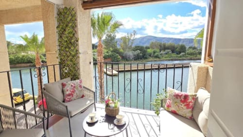 Balcón con vistas al lago de Benicàssim en Apartment Regata con asientos, palmeras y vistas a la montaña