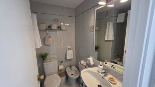 Baño moderno en Apartamento Regata, Benicàssim con azulejos grises, lavabo blanco, inodoro, bidé y ducha